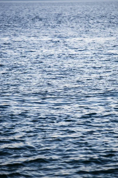 Seaside background.Sun shines on water surface.Adriatic Sea in the evening dusk light.Vertical natural background