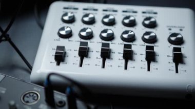 Parti dj & müzik yapımcısı için profesyonel midi denetleyicisinin görüntüleri. Modern ses ekipmanları ile çalmak & remix parçaları. Ses ve ses efektlerini kontrol etmek için faders & regülatörlere odaklanın.