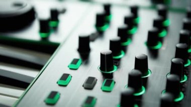 Dj'in konserde remix ve müzik çalması için profesyonel ses ekipmanlarının görüntüleri, parti. Ses kayıt stüdyosu teknolojisi. Midi klavye piyano, faders & regülatörleri ile dijital müzik aleti.