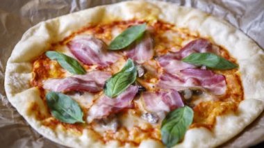 Italyan kafede lezzetli pizza. Italya 'da gelenek yemek görüntüleri, Yeşil fesleğen yaprakları, siyah zeytin, yanmış peynir ve pastırma dilim ile pişmiş hamur tabanı