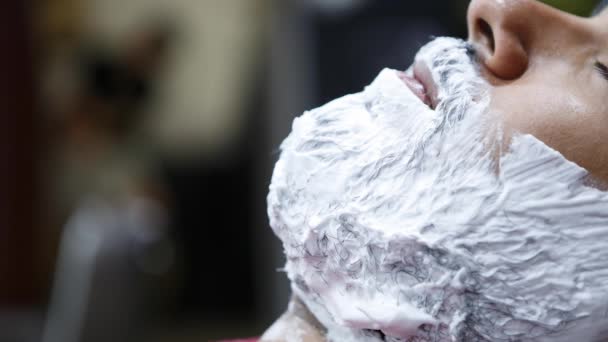얼굴에 크림이있는 이발소 클라이언트 이발소 의자에서 수염을 살롱에서 트리트먼트 이발소에서 — 비디오