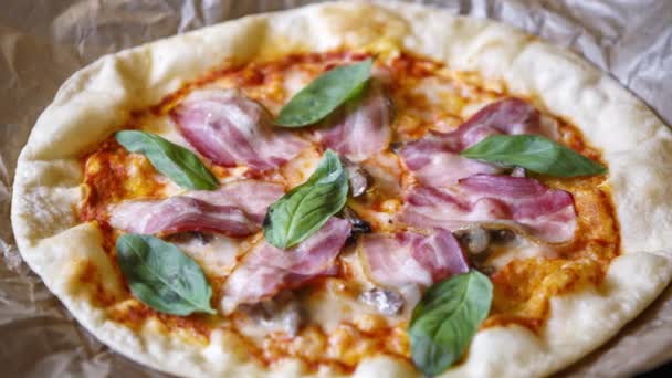 イタリアンカフェでおいしいピザ イタリアの伝統料理の映像 緑のバジルの葉 黒オリーブ 焼いたチーズとベーコンスライスと焼き生地のベース — ストック動画