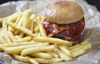 Fastfood restoran menüsünde patates kızartması ile lezzetli hamburger.