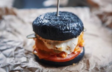 Lezzetli büyük şişman duble hamburgerin görüntüleri. Amerikan Fast food restoran menü çanak. Sos ile ızgara büyük Burger, domuz ve yakıcı peynir kafede kahverengi kağıt üzerinde hizmet vermiştir. Hızlı yiyecek video yakın çekim.