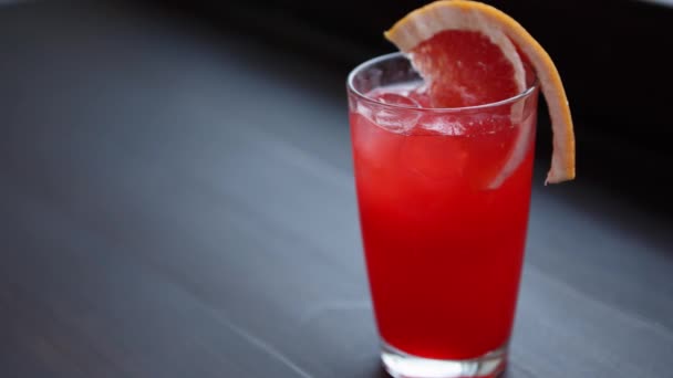 玻璃中的红酸酒精饮料 享受美味的长饮和天然新鲜果汁 在酒吧里喝清凉的长酒 — 图库视频影像