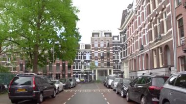 AMSTERDAM, NETHERLANDS - 27 NİSAN, 2019: Amsterdam 'daki eski yerleşim alanının dar caddesinde sıkıca park edilmiş çok sayıda araba.