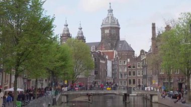 AMSTERDAM, NETHERLANDS - 27 Nisan, 2019: Tarihi evlerle kanal manzarası