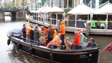 AMSTERDAM, NETHERLANDS - 28 Nisan 2019: Amsterdam 'ın merkezinde yıllık Krallar Günü (Flaman: Koningsdag) kutlaması. Hollanda Krallığı 'nda ulusal tatil. İnsanlar Amstel nehir kanalında kayıklara biniyor. 