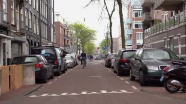 AMSTERDAM, NETHERLANDS - 27 NİSAN, 2019: Amsterdam 'daki eski yerleşim alanının dar caddesinde sıkıca park edilmiş çok sayıda araba.