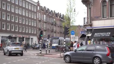 AMSTERDAM, NETHERLANDS - 27 Nisan, 2019: Amsterdam 'ın güzel caddeleri. Kuzey Hollanda 'daki eski Avrupa şehrinin tarihi merkezinde yolda giden arabalar