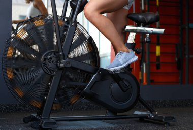 Kapalı spor salonunda bisikletle egzersiz genç kadın