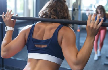 Spor salonunda ağır eğitim. Güçlü kadın atlet halter ile egzersizleri