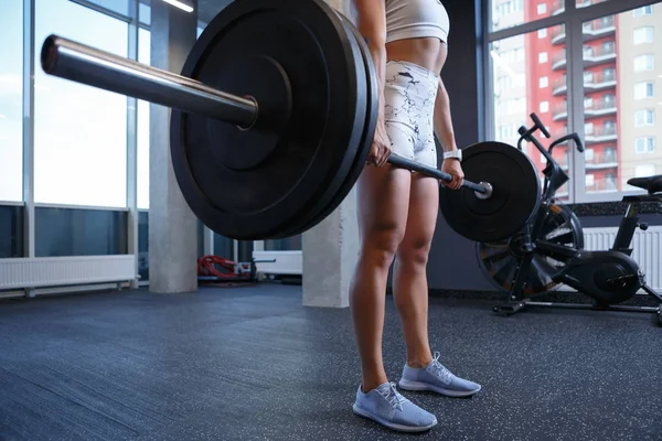 Fuerte joven mujer haciendo sentadillas con enorme barra en el club de gimnasia — Foto de Stock