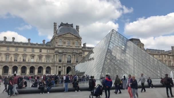 フランス 2019年4月30日 最も有名なフランスのランドマーク ルーブル美術館 美しい博物館の複合体の映像 噴水やガラスの建設は 世界中からの観光客の群衆に囲まれています — ストック動画