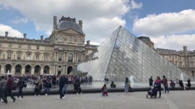 Paris,Fransa-30 Nisan,2019:En ünlü Fransız simgesi - Louvre Museum.Footage güzel müze kompleksi, çeşme ve cam inşaat dünyanın dört bir yanından gelen turist kalabalığı ile çevrili 