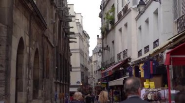 Paris, Fransa-30 Nisan 2019: Dünyanın dört bir yanından gelen turist grubu Notre Dame'ı ziyaret etmek için Paris'e seyahat ediyor. Ünlü dönüm noktası yakın Dar şehir sokakları insanlarla dolu. Sokak yemekleri ve hediyelik eşya dükkanları