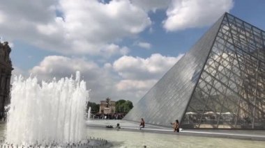 Paris,Fransa-30 Nisan,2019:En ünlü Fransız simgesi - Louvre Museum.Footage güzel müze kompleksi, çeşme ve cam inşaat dünyanın dört bir yanından gelen turist kalabalığı ile çevrili 