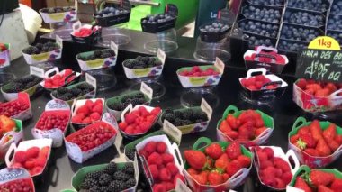 Paris,Fransa-30 Nisan,2019: Sokak gıda pazarında taze çilek, ahududu, böğürtlen satın alın. Paris'te öğle yemeği için doğal tatlı gıdalar