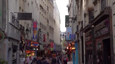 Paris, Fransa-30 Nisan 2019: Dünyanın dört bir yanından gelen turist grubu Notre Dame'ı ziyaret etmek için Paris'e seyahat ediyor. Ünlü dönüm noktası yakın Dar şehir sokakları insanlarla dolu. Sokak yemekleri ve hediyelik eşya dükkanları