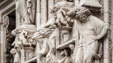 Güzel Duomo di Milano yakından. Beyaz mermer taş heykeller ve heykeller Milan 'ın merkezindeki antik Katolik kilisesinin dış tasarımı. Gotik mimari tarzı detaylar.