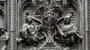 Yakın yukarı güzel Duomo di Milano demir kapılar dekor. Italya 'da Milano şehir merkezinde Antik Katolik kilise dış tasarım İsa Mesih & diğer rakamlar. Gotik mimarisi tarzı detayları