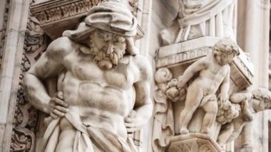 Güzel Duomo di Milano yakından. Beyaz mermer taş heykeller ve heykeller Milan 'ın merkezindeki antik Katolik kilisesinin dış tasarımı. Gotik mimari tarzı detaylar.