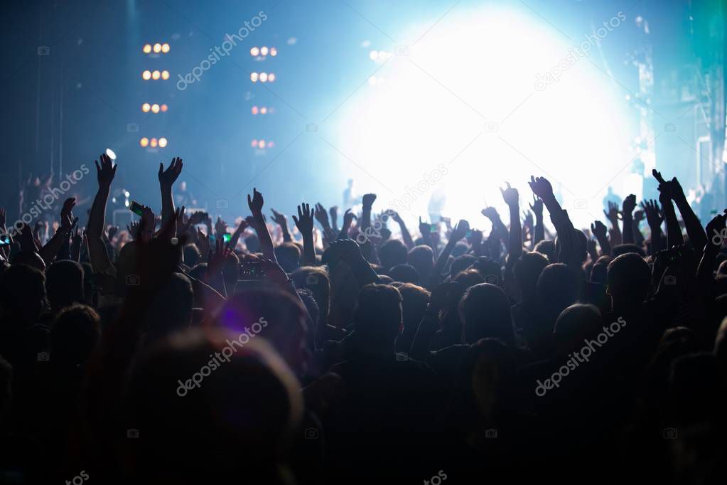 Concert stage lights and crowd on dance floor partying to the music