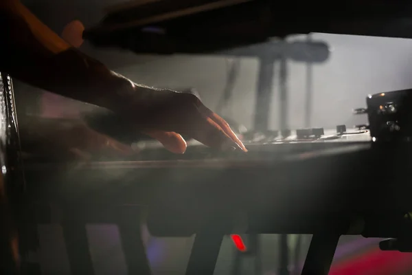 Professional pianist playing live set on stage with keyboard synthesizer