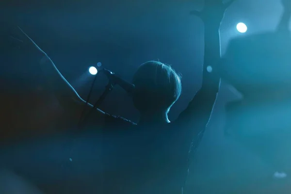 Joven cantante cantando en el escenario en el concierto de rock en la noche clu — Foto de Stock