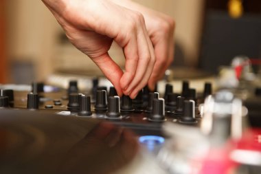 Profesyonel hip hop dj gece kulübünde ses karıştırıcı denetleyici parça karışımları. Partide parça çalan kadın disk jokey. Yüksek kalitede müzik çalmak için ses ekipmanları
