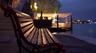 Decorative wooden bench at Grand Canal waterfront in Venice in blue hour.Venetian backstreets in the evening