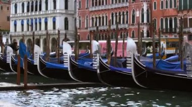 VENICE,ITALY-4 MAY,2019:Decorated gondola boats in Grand Canal.Traditional venetian water transport,popular tourist attraction.Gondolas floating on water in Venezia near Rialto Bridge
