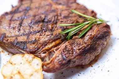 Akdeniz restoranında akşam yemeği için ızgara biftek ve biberiye yaprağı. Izgarada pişmiş lezzetli kırmızı köfte.