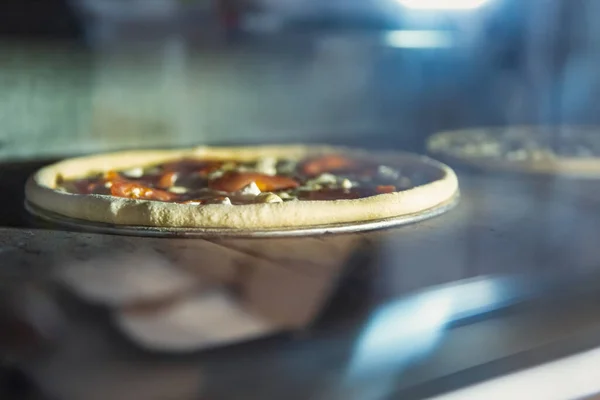 Baking pizza in restaurant.Italian pizzeria bakes pizzas in electric oven for dinner