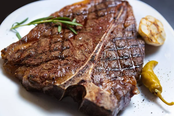 アメリカの肉料理店のグリルで調理されたグルメTボーンステーキ ダイナーのカフェで夕食に提供される白いセラミックプレート上のおいしいステーキ — ストック写真