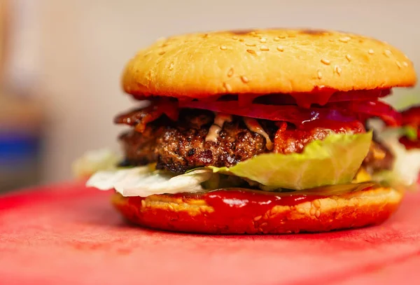 Big fat burger cooking in fat food restaurant kitchen in close up