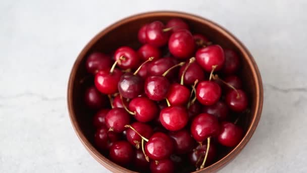 Filmagem Deliciosos Frutos Cereja Vermelha Tigela Cerâmica Marrom Mesa Mármore — Vídeo de Stock