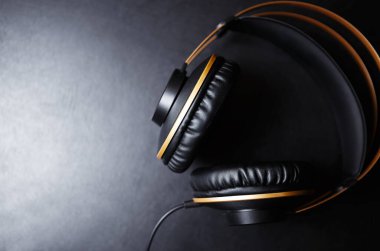 Düz arkaplan içinde siyah kulaklıklar fotokopi alanı ile boş arkaplanda yatıyor.Profesyonel kablo DJ 'i gece kulübü partisi için güçlü bir sesle donattı. Ses kayıt stüdyosundaki müzisyenler için Hifi ses monitörleri