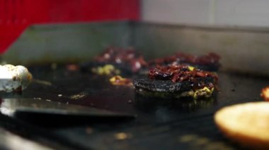 Restoran mutfağında akşam yemeği için sıcak tavada kızarmış hamburger pirzolası. Biftek pişirme sahnesi. Amerikan lokantasında hamburger için yağda kızartılmış domuz kızartması.