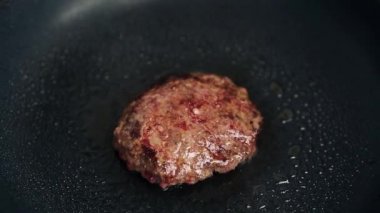 Geleneksel Amerikan hamburgeri yakından pişiriliyor. Mutfakta kızgın tavada kızartılmış domuz eti. Hamburger yemeği için doğal malzeme.
