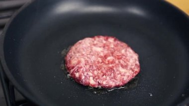 Sıcak tavada kızartılan çiğ sığır pirzolası. Akşam yemeği için evde pişen doğal kıymalı et. Geleneksel Amerikan hamburgerine taze köfte hazırlama görüntüsü. 