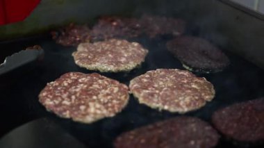 Restoran mutfağında akşam yemeği için sıcak tavada kızarmış hamburger pirzolası. Biftek pişirme sahnesi. Amerikan lokantasında hamburger için yağda kızartılmış domuz kızartması.