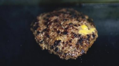 Burgre pirzolasının tavada kızartılışı ve erimiş mavi peynir. Amerikan fast food restoranında ızgarada pişen sağlıksız domuz eti köftesi. Akşam yemeği için fast food hazırlığı.  