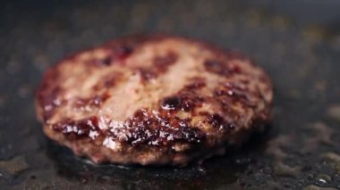 Restoran mutfağında akşam yemeği için sıcak tavada kızartılmış hamburger eti. Biftek pişirme sahnesi. Amerikan lokantasında hamburger için yağda kızartılmış domuz kızartması.