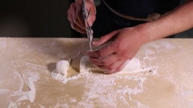 Aşçı, restoran mutfağındaki ahşap masada taze peynirli ve buğday unlu cheesecake hazırlıyor. Geleneksel Rus şurubu pişirme işleminin video klibini kapatın.