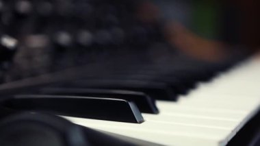Analog sentezleyici klavyesinde siyah ve beyaz piyano tuşları yakınlaştırarak çekildi. Ses kayıt stüdyosundaki müzisyenler için profesyonel müzik aletleri. Midi synth destesi ile yeni müzik oluştur.