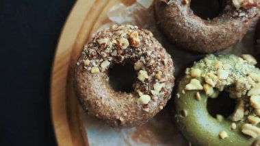 Yukarıdan çekilen fırınlanmış taze donutlar. Pasta kafedeki lezzetli fırın ürünleri öğle yemeği için kafedeki ahşap tabakta servis ediliyor. Kahve molası için kremalı ve fındıklı geleneksel Hollanda çöreklerinin tadını çıkarın.