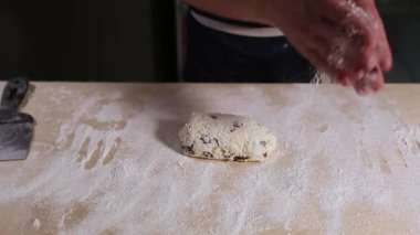 Aşçı, restoranın mutfağındaki masada buğday ununda yumuşak süzme peynirli cheesecake hazırlıyor. Yukardan çekilen video klipte geleneksel Rus şurubu tatlı yemeği görüntüsü var.