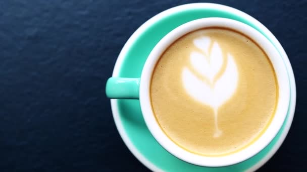 一杯新鲜的早晨卡布奇诺咖啡 用陶瓷杯直接从上面拍下来 用热能量饮料做早餐的视频剪辑 享受芬芳的意大利拿铁 泡沫层上有花束 — 图库视频影像