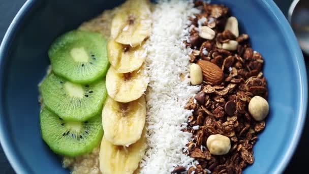 Friska Frukostmål Med Havregrynsgröt Skivade Kiwi Bananfrukter Hasselnötter Mandel Serveras — Stockvideo